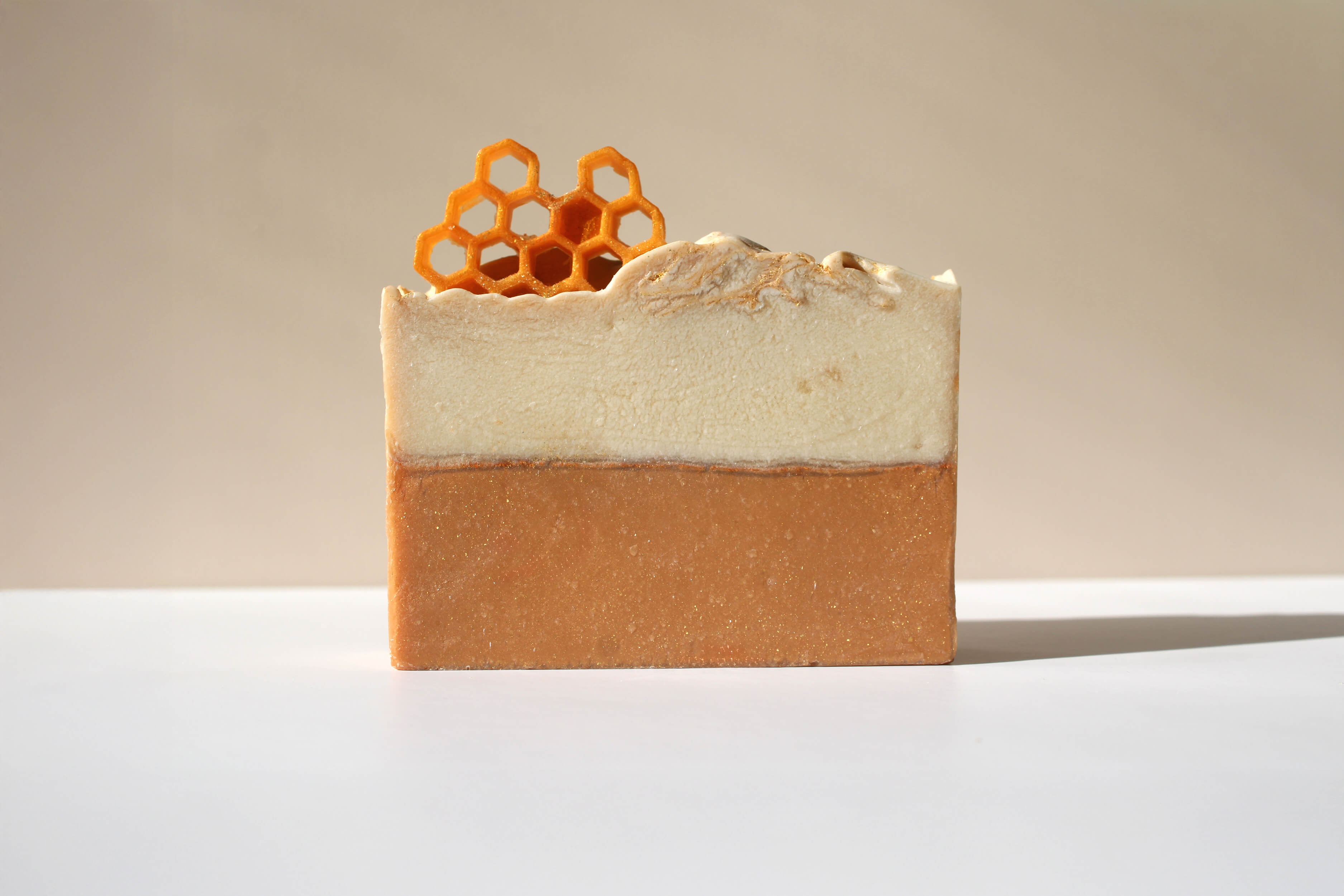 Bar of soap with a honeycomb decoration on a beige background