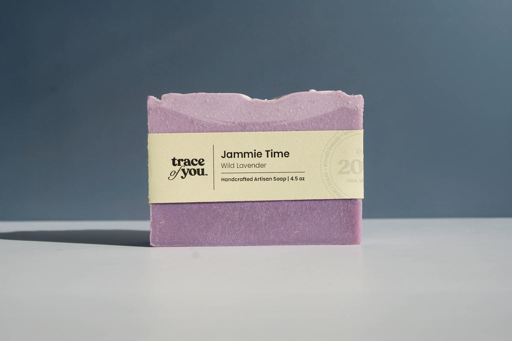 Purple soap bar with a label on a gray surface and dark background