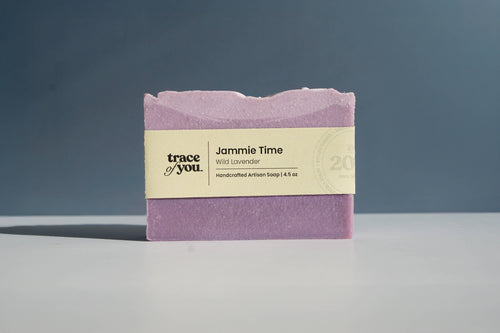 Purple soap bar with a label on a gray surface and dark background