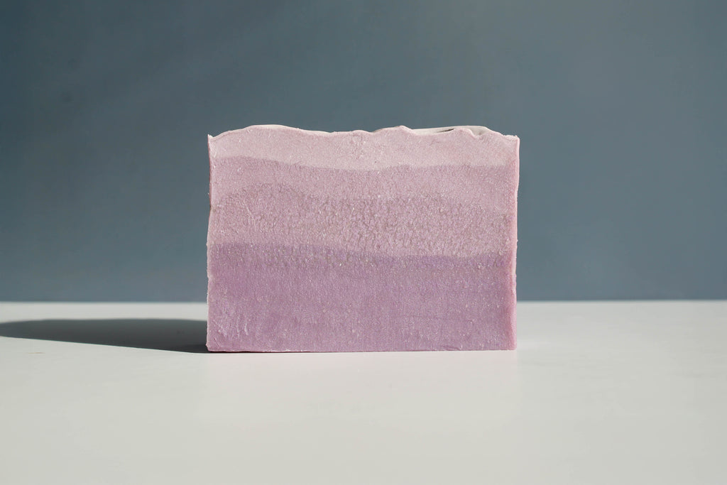 Pink and purple striped soap bar on a gray background
