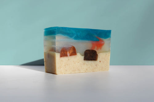 Bar of soap with colorful layers on a light blue background