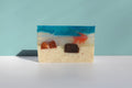 Colorful soap bar with a beach scene design on a light blue background
