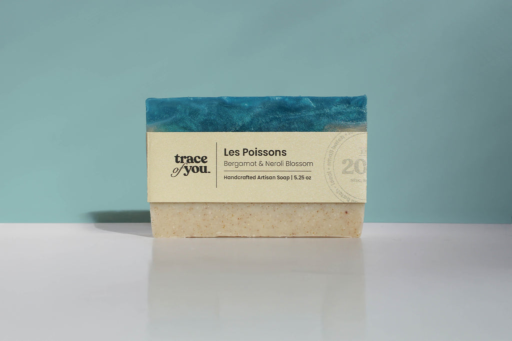 Bar of soap with a blue and beige label on a white surface and light blue background