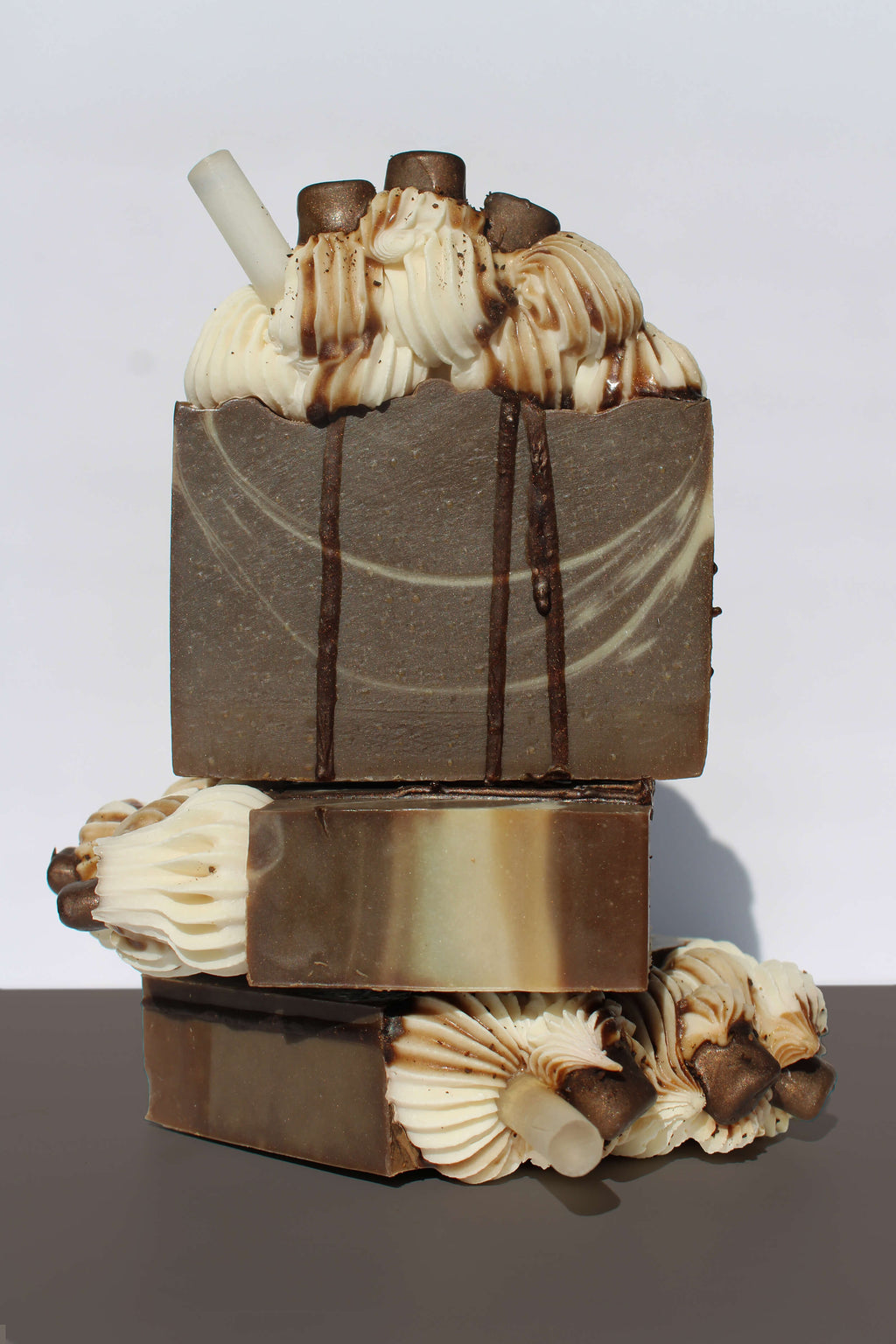 Stack of layered soap bars with decorative elements on a white background