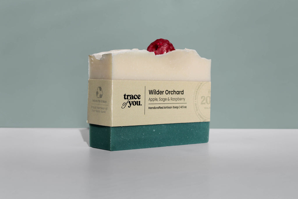 Bar of soap with a red berry on top, branded 'trace of you', against a gray background
